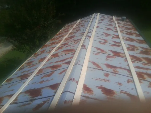 Rusted metal roof panels with new wood purlins before replacement — Storm Damage Roof Repair in Reedsburg by Roofing Brothers