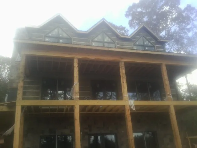 Dormers and porch framing on a large log home under construction — Roof Coating work by our crew in Reedsburg