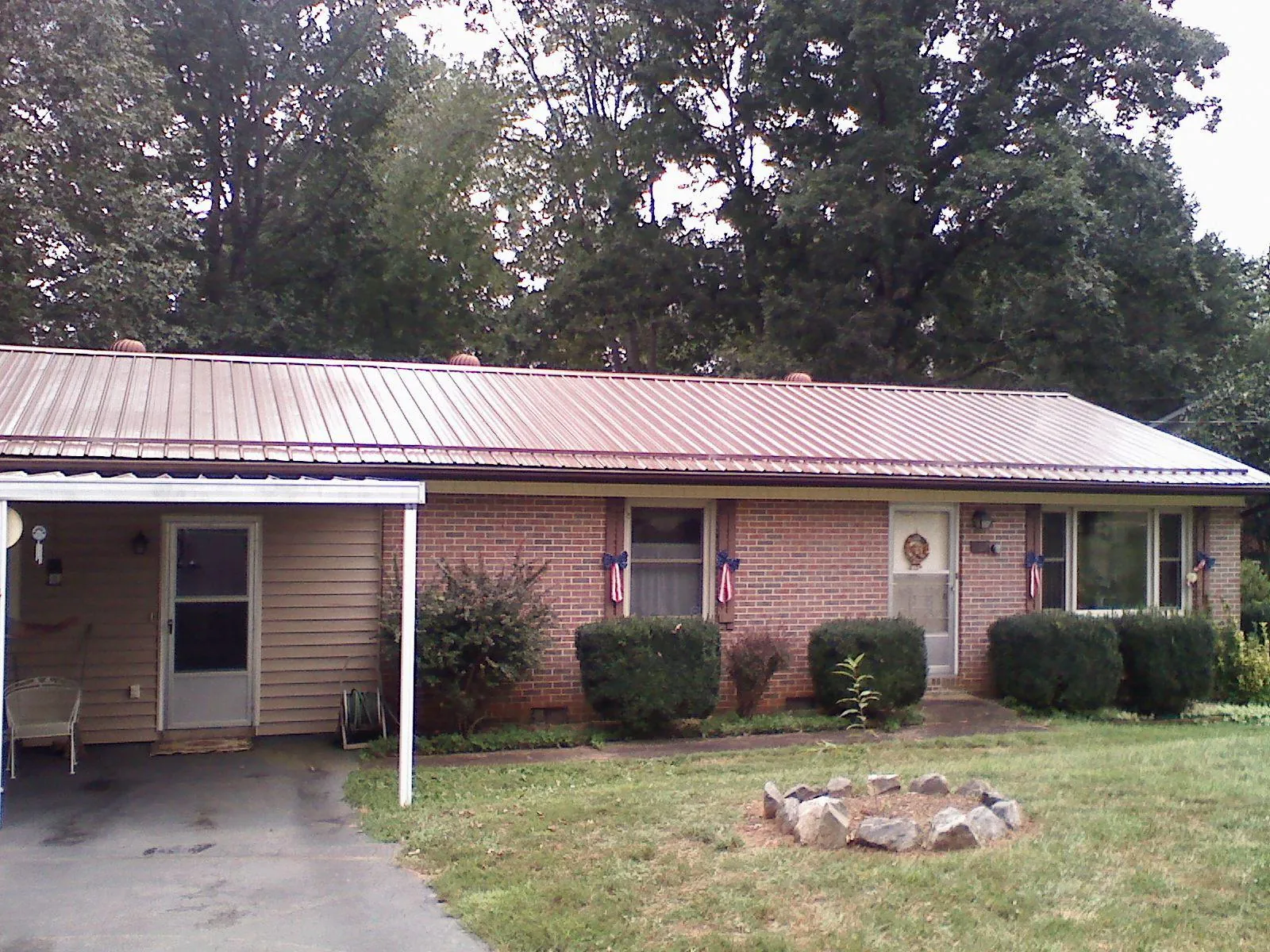 Bronze metal roof and carport on a brick ranch home — Roof Repair work by our crew in Reedsburg